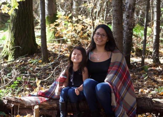 Caregiver and Daughter sitting in forest